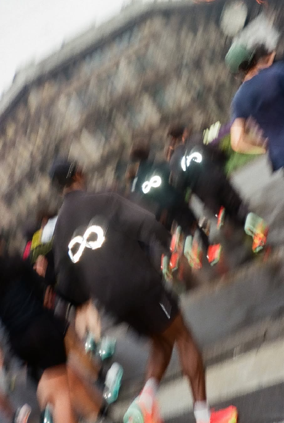 Runners from behind wearing infinity-logo jerseys